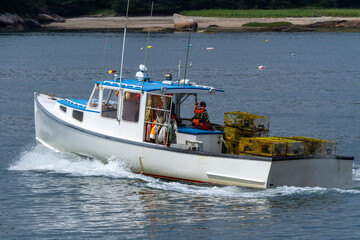 A Lobster boat with traps heading out to check his traps.