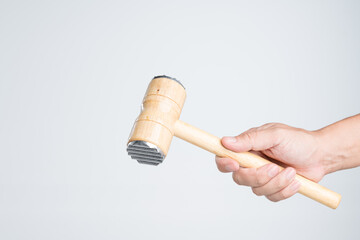 Hand holding meat tenderizer mallet or food hammer