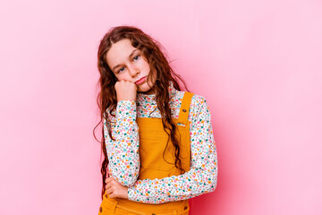 Little caucasian girl isolated on pink background tired of a repetitive task.