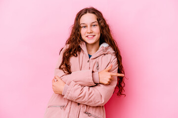 Fototapeta premium Little caucasian girl isolated on pink background smiling cheerfully pointing with forefinger away.