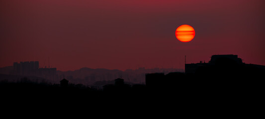Beautiful red sunset over the silhouette of an urban skyline in Seoul, South Korea. 