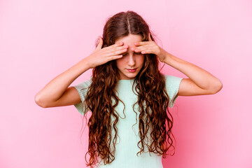 Fototapeta premium Little caucasian girl isolated on pink background having a head ache, touching front of the face.