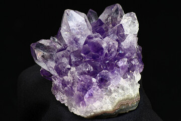 Amethyst druse on a dark background close up. Cluster of lilac crystals
