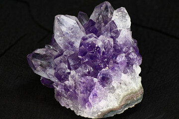 Amethyst druse on a dark background close up. Cluster of lilac crystals