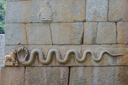 Chitradurga, Karnataka, India - November 10, 2013: Fort or Elusuttina Kote. Closeup of snake sculpture on main entrance gate wall in brown-gray stone.