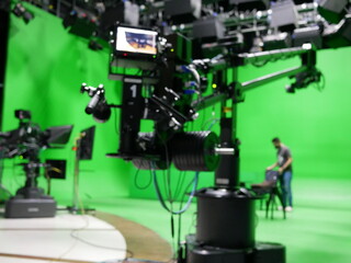 abstract blurred of broadcast camera in studio with greenscreen at TV station.
