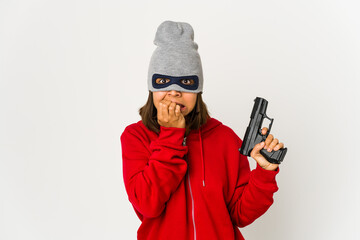 Young robber hispanic woman wearing a mask biting fingernails, nervous and very anxious.