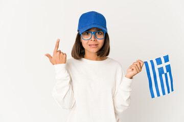 Young hispanic mixed race woman holding a greece flag showing a disappointment gesture with forefinger.