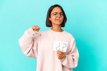 Young hispanic mixed race woman holding an interrogation board showing a dislike gesture, thumbs down. Disagreement concept.