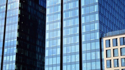 The glass facade of a skyscraper. Modern office building and sky reflection.
