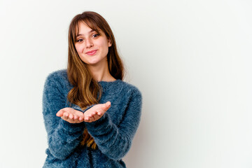 Young caucasian cute woman isolated on white background folding lips and holding palms to send air kiss.