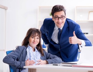Pregnant woman struggling in the office and getting colleague he