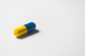 capsule in yellow and blue color, medicine on white background