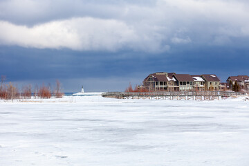 An old, wooden bridge crosses a section of frozen Georgian Bay waterfront in Collingwood, Ontario....