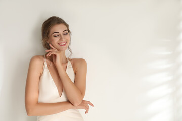 Naklejka premium Young bride wearing beautiful wedding dress on light background. Space for text