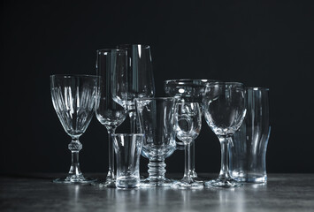 Set of bar glassware on table against dark background