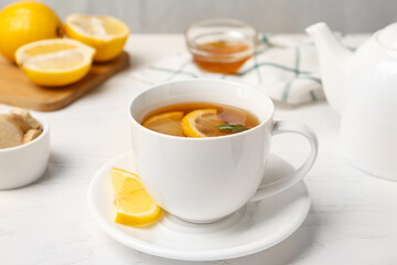 Fototapeta premium Hot tea with mint and lemon on white table