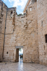 Croatia, Split. Radic Brothers Square also known as Fruits Square. Venetian watch tower built in 1400's. People on Riva framed by stone entry.
