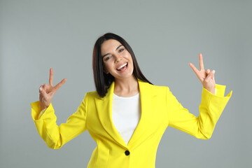 Woman showing number four with her hands on grey background