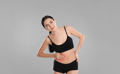 Fototapeta premium Woman suffering from liver pain on grey background