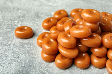 Tasty hard toffee candies on light grey table, closeup