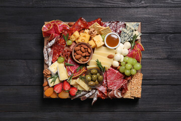 Assorted appetizers served on black wooden table, top view