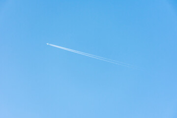 Avião a jato com rastro no céu azul