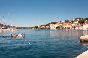 Croatia, Brac, Milna. Fisherman returns to quay calm morning.