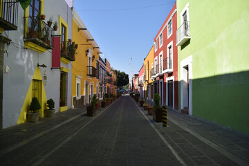 Fototapeta na wymiar Street with colorful locals and houses in Puebla