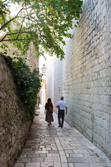 Croatia, Dubrovnik. Walled old city. Couple walks uncrowded stone lane.