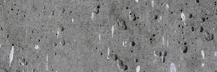Texture of old concrete wall. Rough gray concrete surface with white paint spots. Wide panoramic background for design.