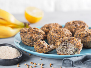 Close-up view of healthy gluten-free homemmade banana muffins with buckwheat flour. Vegan muffins with poppy seeds on blue plate over gray wooden table. Copy space