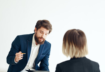 A man in a classic suit is talking to a female psychologist communication work office