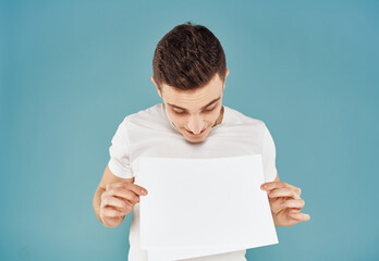 Male advertiser with a white sheet of paper on a blue background mockup Flyer