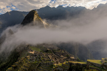 Fototapeta premium The old Inca city-temple of Machu Picchu surrounded by a cloud of fog