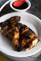 Grilled chicken served with plain white rice and cucumber on a polystyrene plate. Healthy menu.