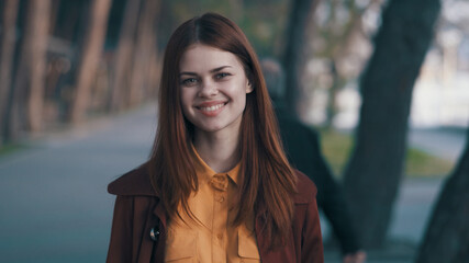 Fototapeta premium cheerful pretty woman coat outdoors in the park smile