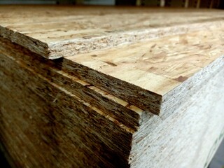 A stack of plywood sheets for construction. A pile of wooden chipboard sheets. Osb plywood.