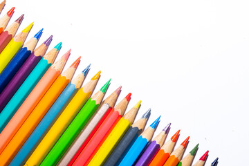 partial view of row of color pencils on white background