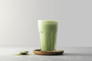 A glass of matcha tea on a concrete background with  copy space.