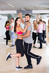 Dancing positive american couples learning salsa at dance class