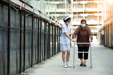 Nurse is helping Senior Elderly Asian Woman uses Zimmer frame walker