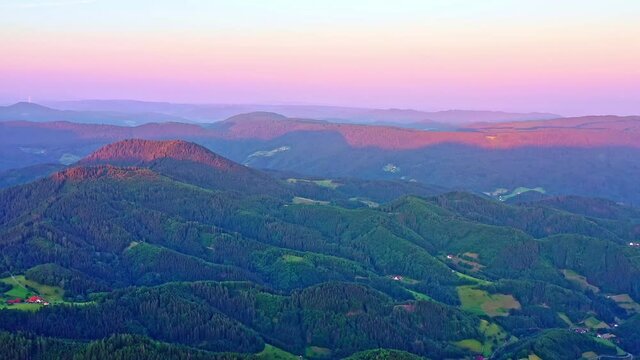 Aerial shot of green-covered mountains in the sunshine, taken in the Herzogenhorn Mountain, Germany