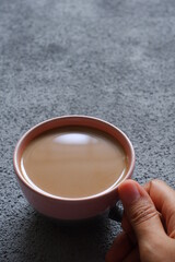 a cup of coffee in a grey background