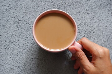 a cup of coffee in a grey background