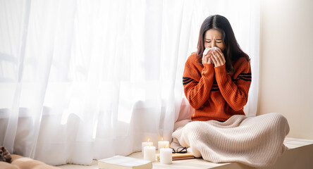 Young asia woman have a cold blowing her runny nose with tissue paper. Portrait of Asian beautiful girl get sick sneezing from flu in her office. Healthcare medical overload burnout, winter concept © paulaphoto