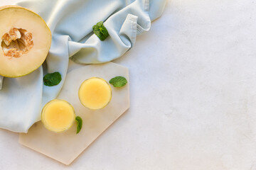 Glasses with melon smoothie on light background
