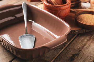 Baking dish and spatula on wooden background, closeup