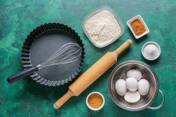 Set of kitchen utensils and ingredients for preparing bakery on color background
