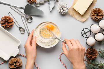 Woman preparing dough on light background